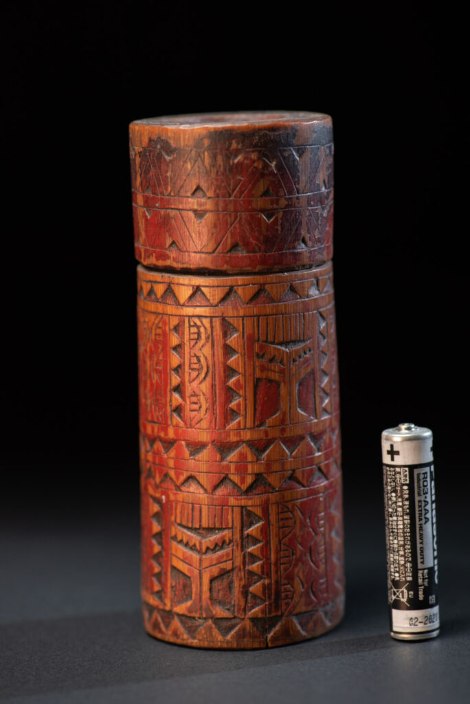 Shaman Bamboo case from the Paiwan tribe carved with geometrics patterns and tint with red pigments.