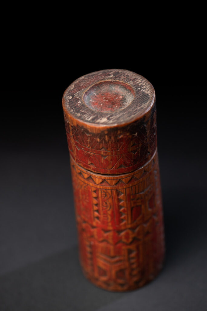 Shaman Bamboo case from the Paiwan tribe carved with geometrics patterns and tint with red pigments.