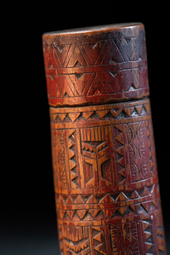 Shaman Bamboo case from the Paiwan tribe carved with geometrics patterns and tint with red pigments.
