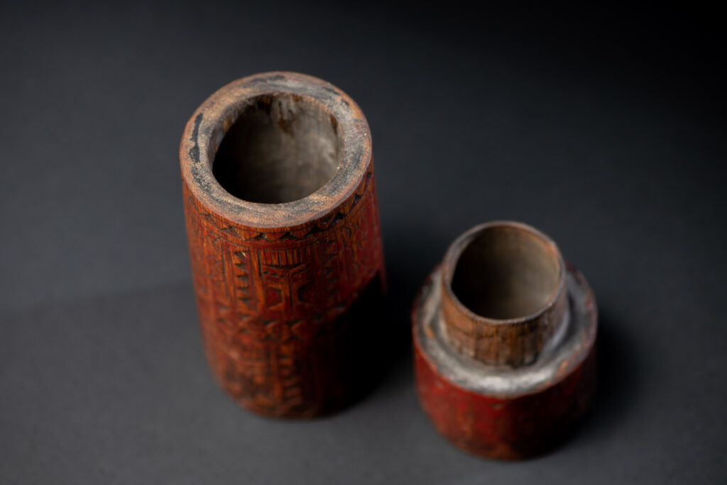 Shaman Bamboo case from the Paiwan tribe carved with geometrics patterns and tint with red pigments.
