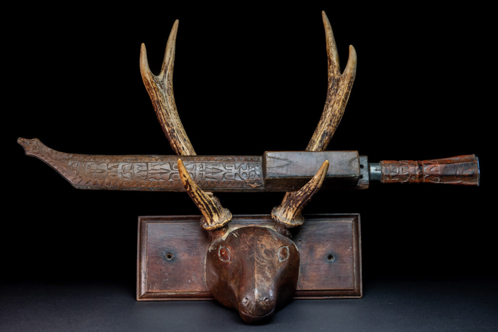 This great sword from the Paiwan tribe is decorated with embossed brass engraved with faces on the front and the side while the back is carved with three characters in the pure Paiwan style.