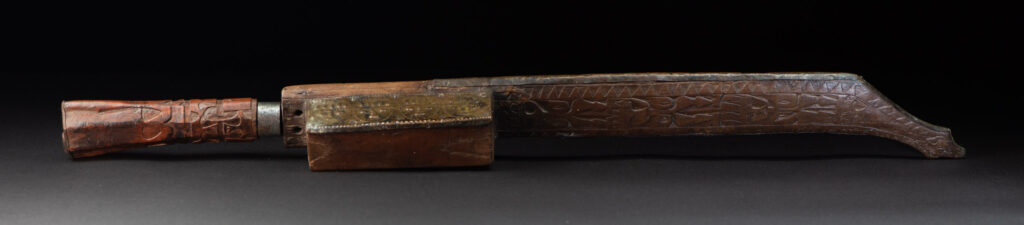 This great sword from the Paiwan tribe is decorated with embossed brass engraved with faces on the front and the side while the back is carved with three characters in the pure Paiwan style.