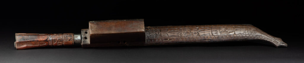 This great sword from the Paiwan tribe is decorated with embossed brass engraved with faces on the front and the side while the back is carved with three characters in the pure Paiwan style.