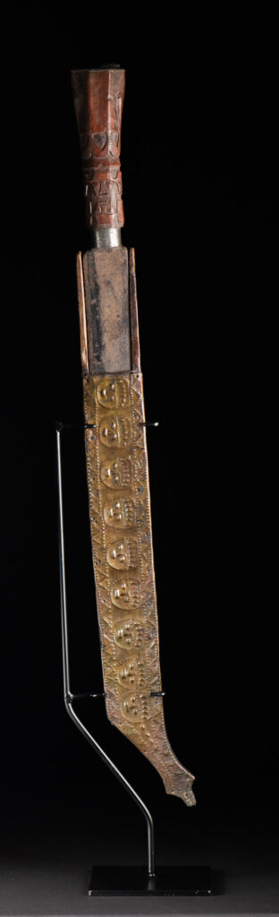 This great sword from the Paiwan tribe is decorated with embossed brass engraved with faces on the front and the side while the back is carved with three characters in the pure Paiwan style.