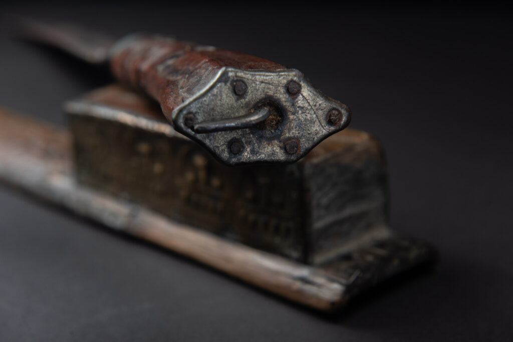 This great sword from the Paiwan tribe is decorated with embossed brass engraved with faces on the front and the side while the back is carved with three characters in the pure Paiwan style.