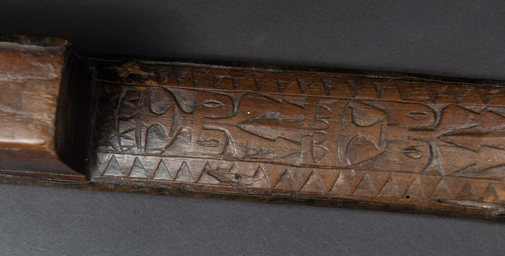 This great sword from the Paiwan tribe is decorated with embossed brass engraved with faces on the front and the side while the back is carved with three characters in the pure Paiwan style.