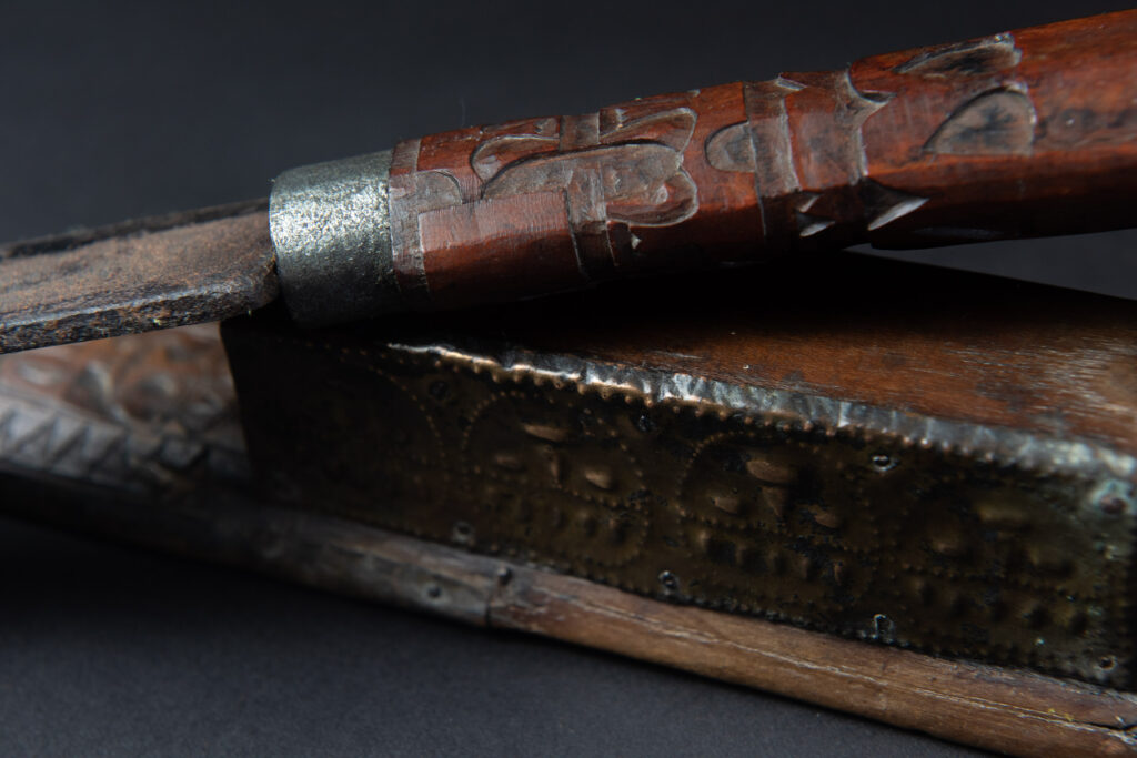 This great sword from the Paiwan tribe is decorated with embossed brass engraved with faces on the front and the side while the back is carved with three characters in the pure Paiwan style.