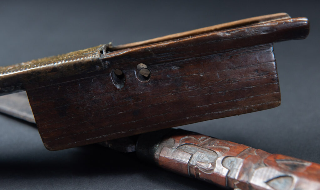 This great sword from the Paiwan tribe is decorated with embossed brass engraved with faces on the front and the side while the back is carved with three characters in the pure Paiwan style.