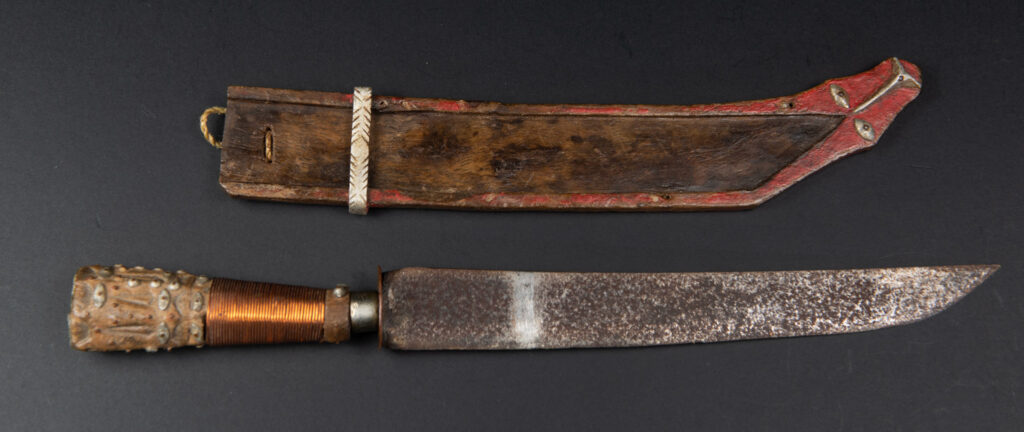 Paiwan tribe knife with the sheath paint in red . The handle is wrapped with copper string