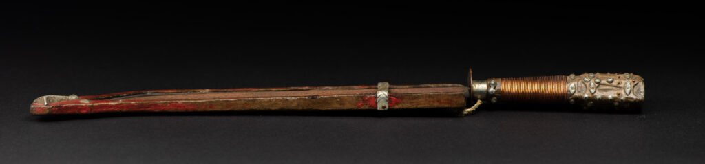 Paiwan tribe knife with the sheath paint in red . The handle is wrapped with copper string