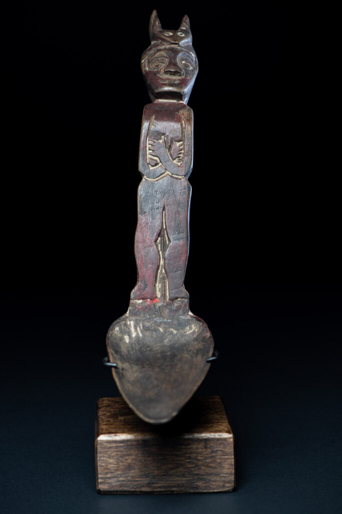 Old spoon from the Paiwan tribe, tinted with red pigments and depicting an ancestor wearing a ceremonial headdress.