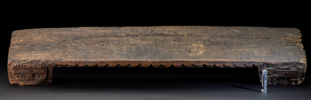 Paiwan tribe headrest in wood carved with human head pattern and deer on both side which represent abundant harvest and performance of ability.