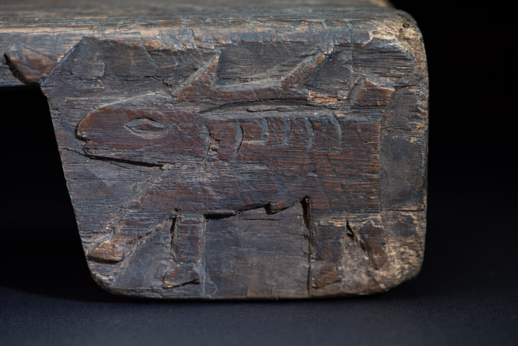 Paiwan tribe headrest in wood carved with human head pattern and deer on both side which represent abundant harvest and performance of ability.