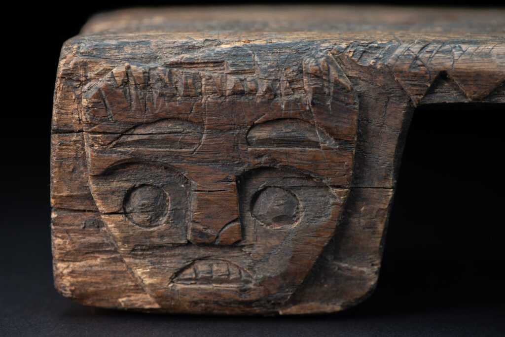 Paiwan tribe headrest in wood carved with human head pattern and deer on both side which represent abundant harvest and performance of ability.