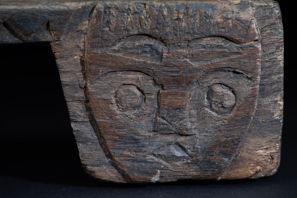 Paiwan tribe headrest in wood carved with human head pattern and deer on both side which represent abundant harvest and performance of ability.