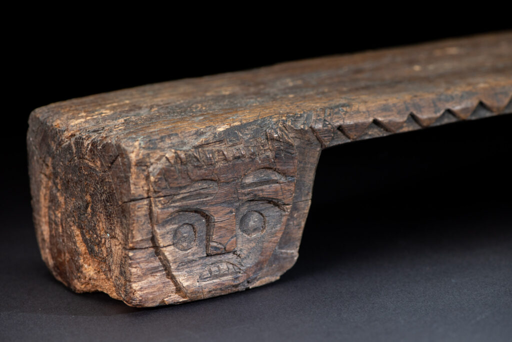 Paiwan tribe headrest in wood carved with human head pattern and deer on both side which represent abundant harvest and performance of ability.