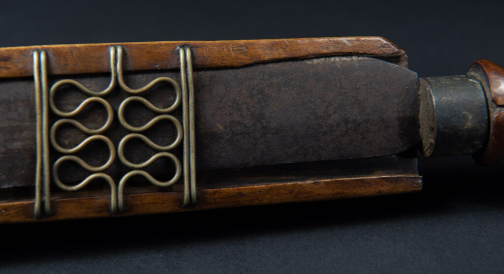 Very fine sword from the Paiwan tribe, carved with the sacred snake and human faces along the sides. The hilt features a full-length standing figure.