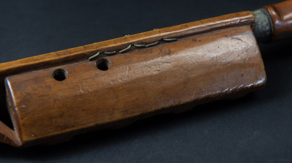 Very fine sword from the Paiwan tribe, carved with the sacred snake and human faces along the sides. The hilt features a full-length standing figure.