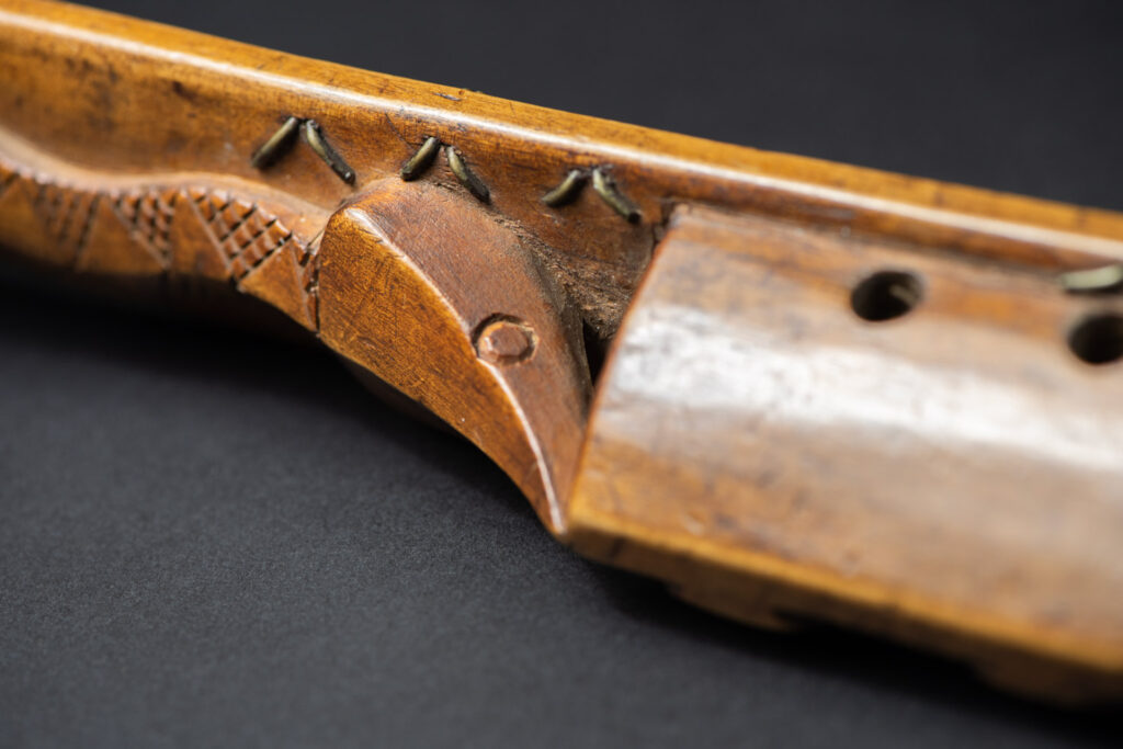 Very fine sword from the Paiwan tribe, carved with the sacred snake and human faces along the sides. The hilt features a full-length standing figure.