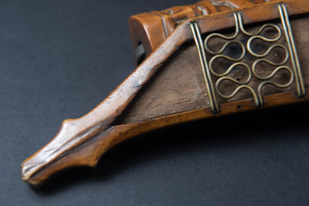 Very fine sword from the Paiwan tribe, carved with the sacred snake and human faces along the sides. The hilt features a full-length standing figure.