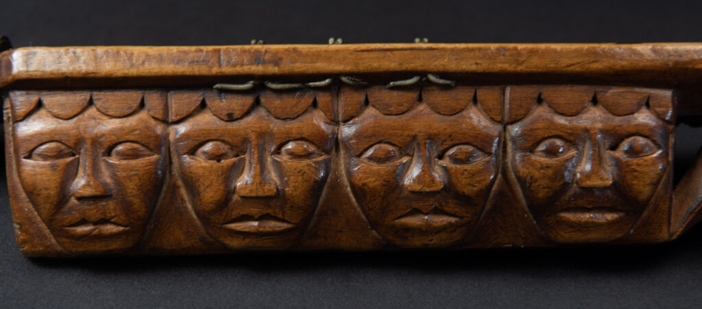 Very fine sword from the Paiwan tribe, carved with the sacred snake and human faces along the sides. The hilt features a full-length standing figure.