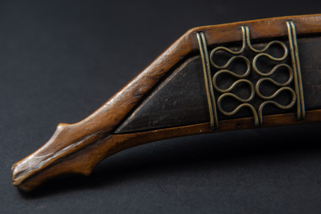 Very fine sword from the Paiwan tribe, carved with the sacred snake and human faces along the sides. The hilt features a full-length standing figure.