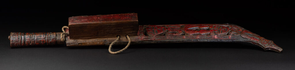 Paiwan tribe ancient sword painted in red, carved with standing figures and humain faces on the side.