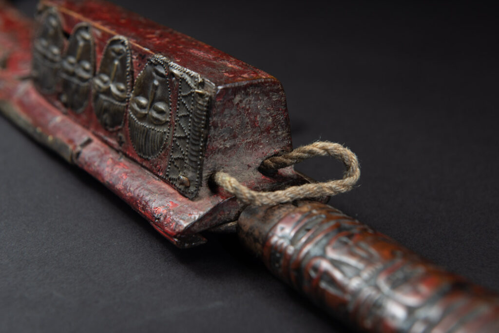 Paiwan tribe ancient sword painted in red, carved with standing figures and humain faces on the side.