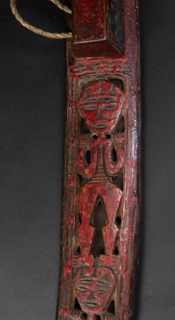 Paiwan tribe ancient sword painted in red, carved with standing figures and humain faces on the side.