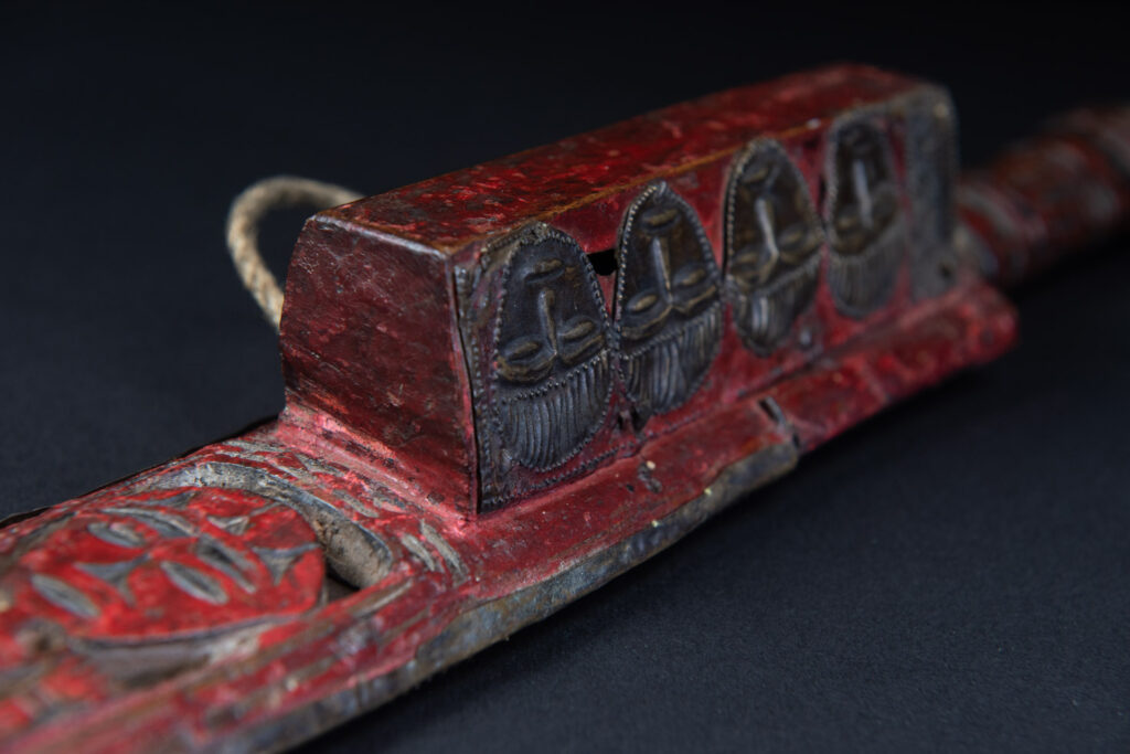 Paiwan tribe ancient sword painted in red, carved with standing figures and humain faces on the side.