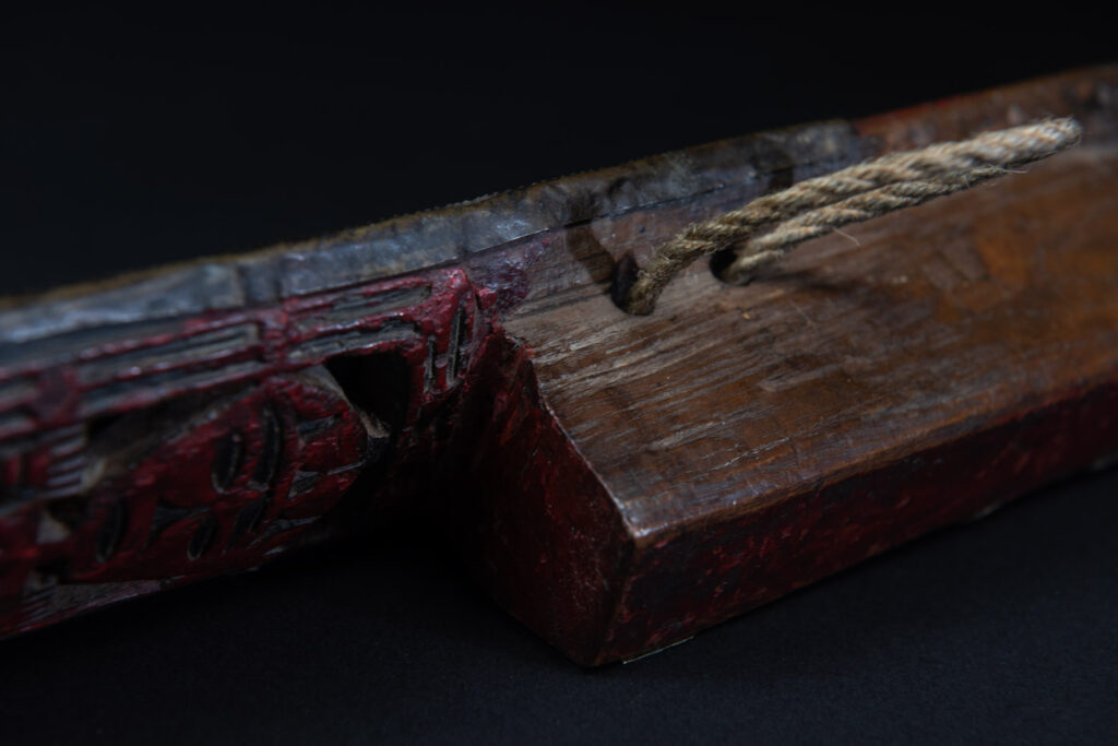 Paiwan tribe ancient sword painted in red, carved with standing figures and humain faces on the side.