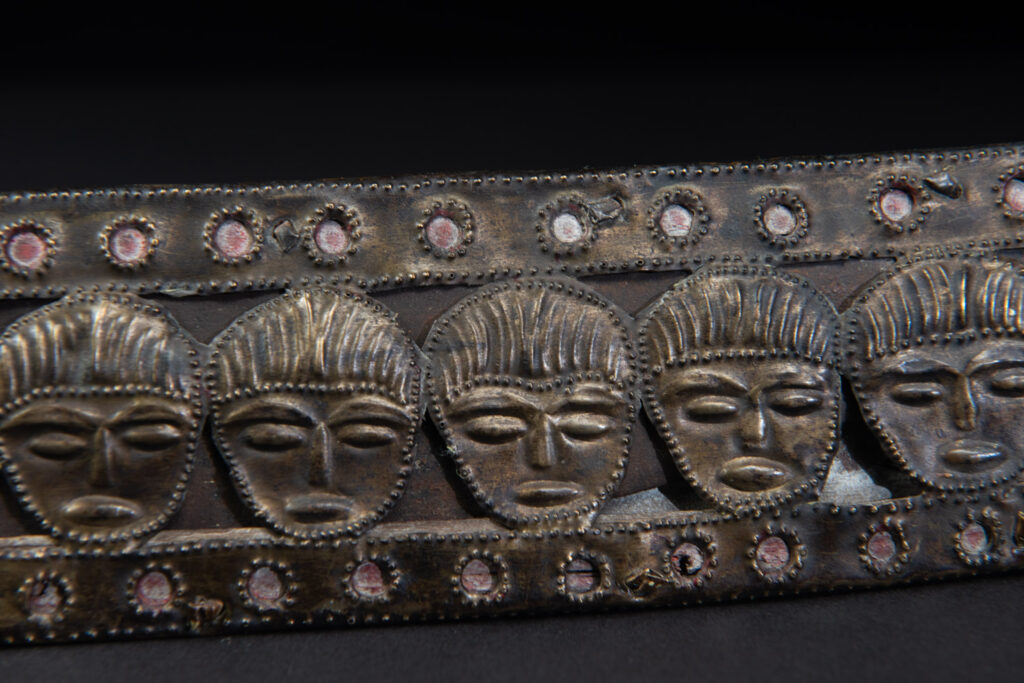 Paiwan tribe ancient sword painted in red, carved with standing figures and humain faces on the side.