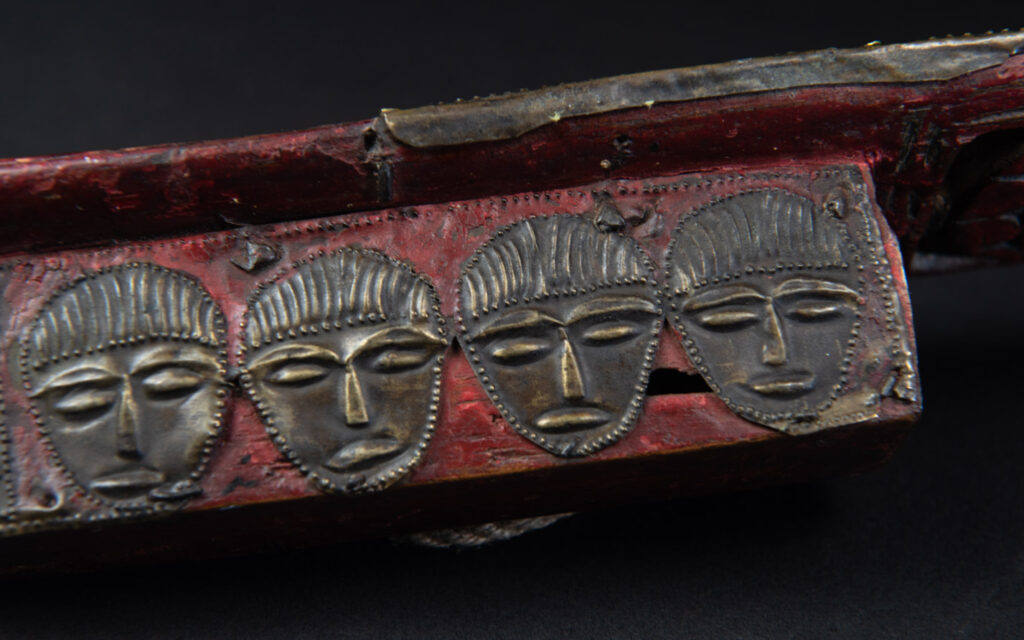 Paiwan tribe ancient sword painted in red, carved with standing figures and humain faces on the side.