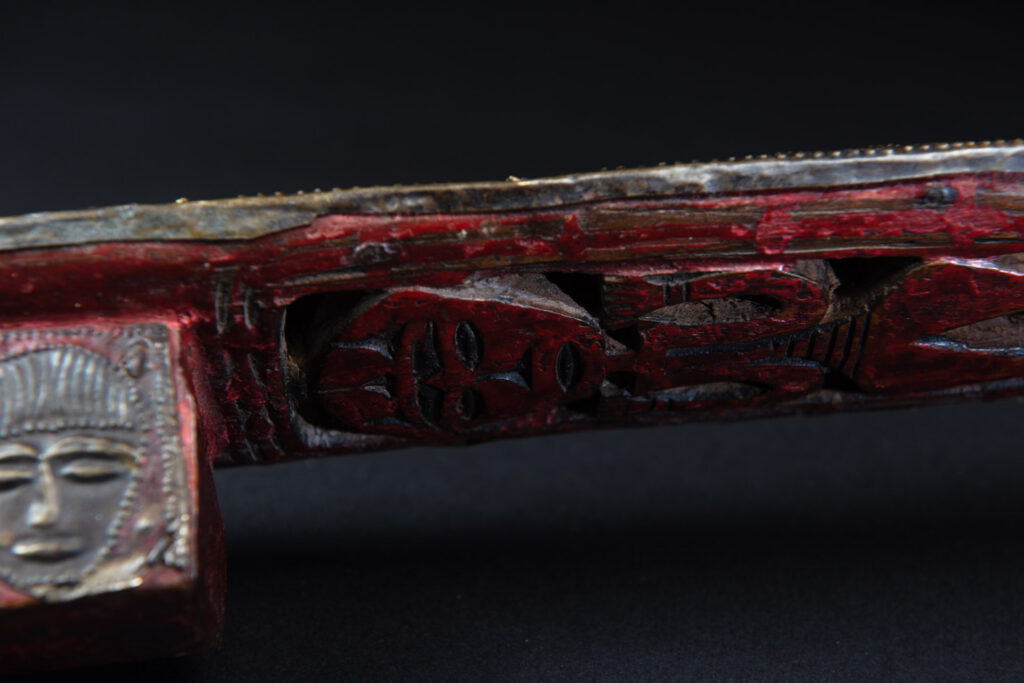 Paiwan tribe ancient sword painted in red, carved with standing figures and humain faces on the side.
