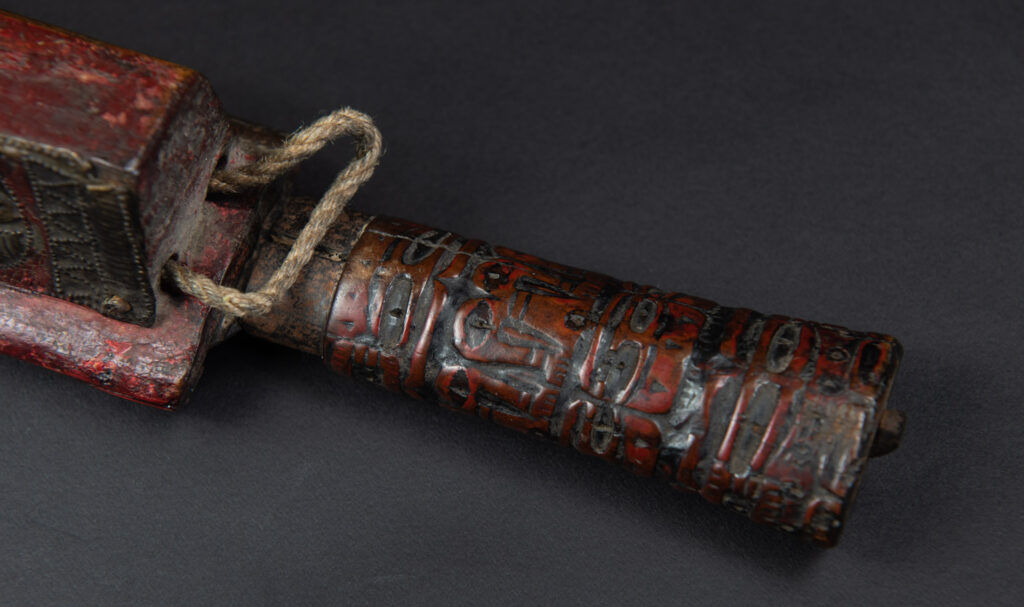 Paiwan tribe ancient sword painted in red, carved with standing figures and humain faces on the side.