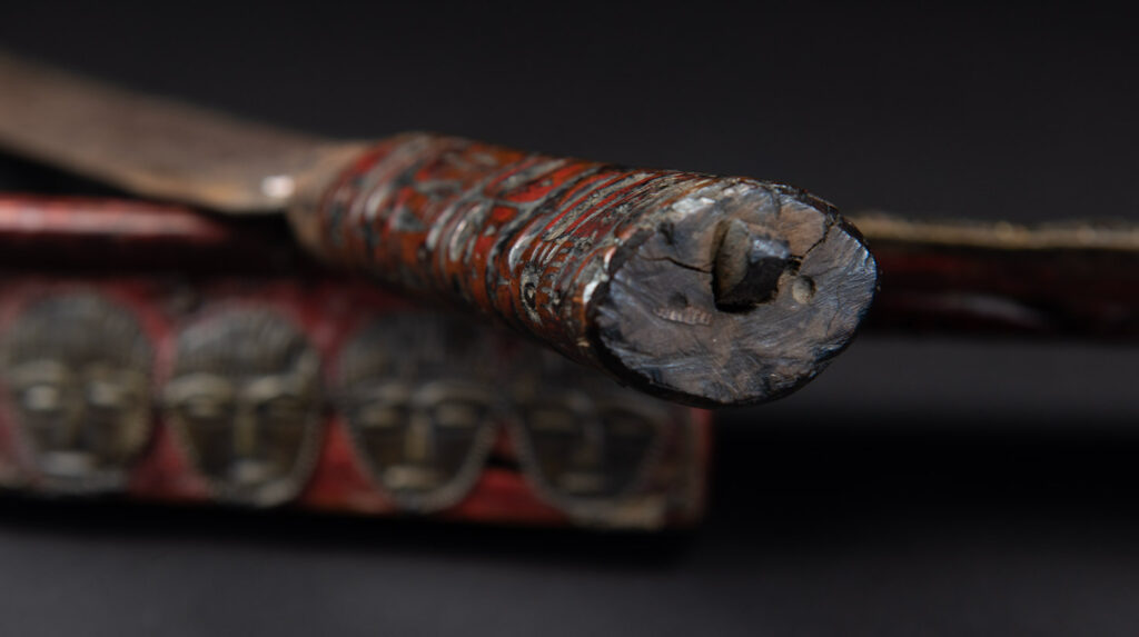 Paiwan tribe ancient sword painted in red, carved with standing figures and humain faces on the side.