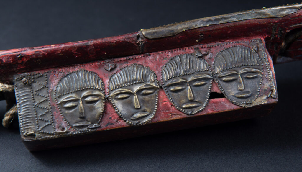 Paiwan tribe ancient sword painted in red, carved with standing figures and humain faces on the side.