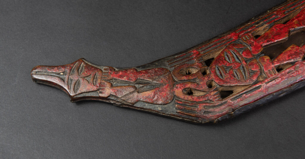 Paiwan tribe ancient sword painted in red, carved with standing figures and humain faces on the side.