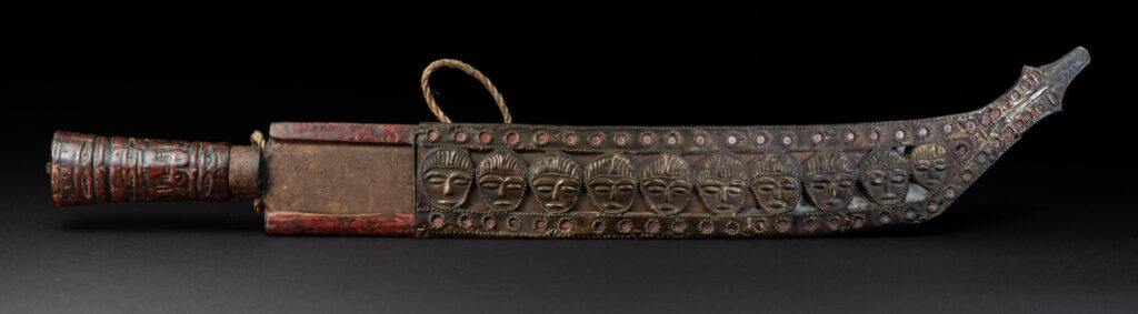 Paiwan tribe ancient sword painted in red, carved with standing figures and humain faces on the side.