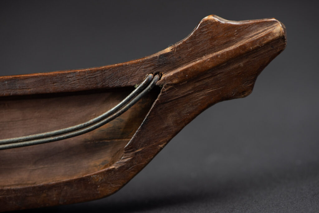 Very fine old sword from the Paiwan tribe, with a scabbard carved with multiple human faces. One side is inlaid with three faience circles.