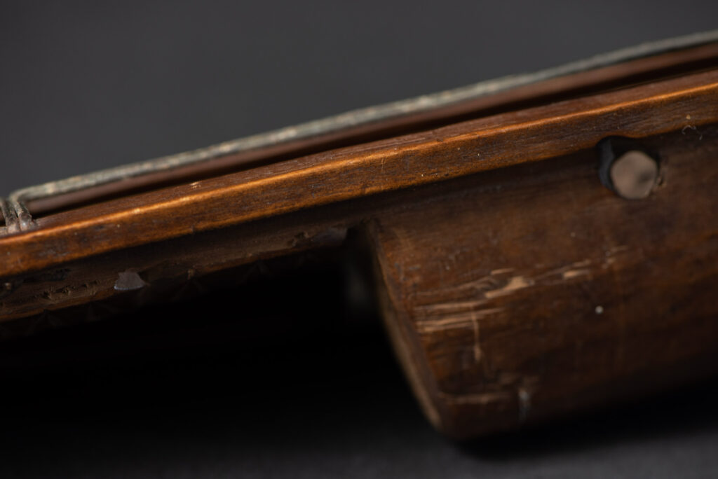 Very fine old sword from the Paiwan tribe, with a scabbard carved with multiple human faces. One side is inlaid with three faience circles.