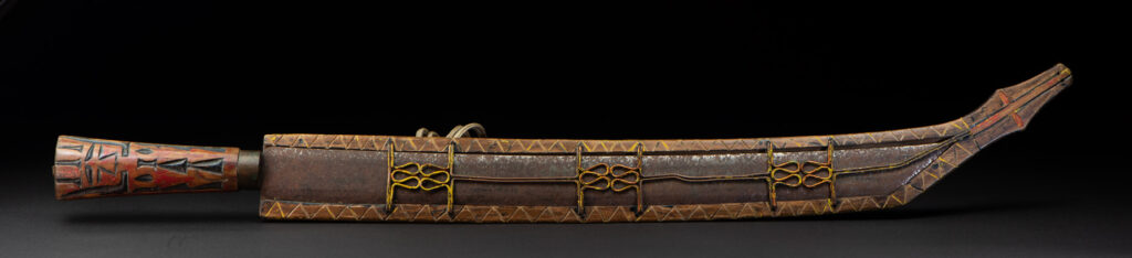 Paiwan tribe sword with a sheath carved with several standing figure and painted in red.