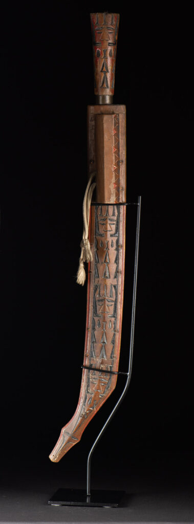 Paiwan tribe sword with a sheath carved with several standing figure and painted in red.