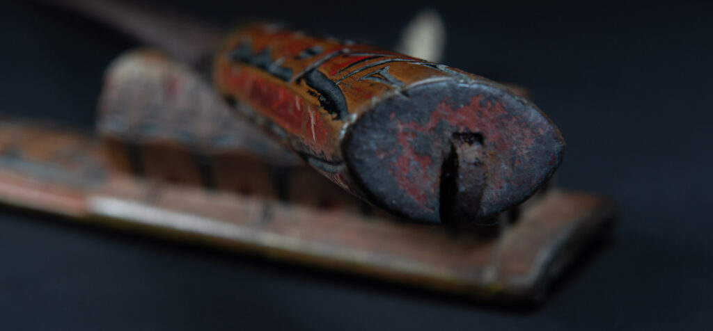 Paiwan tribe sword with a sheath carved with several standing figure and painted in red.