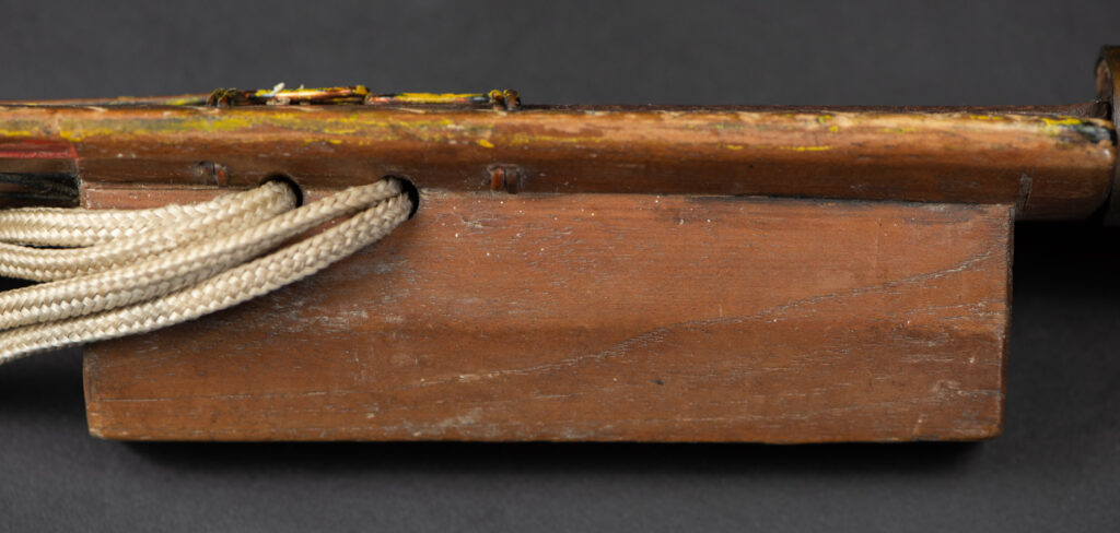 Paiwan tribe sword with a sheath carved with several standing figure and painted in red.