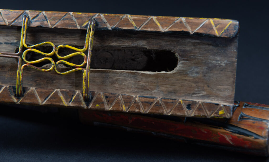 Paiwan tribe sword with a sheath carved with several standing figure and painted in red.