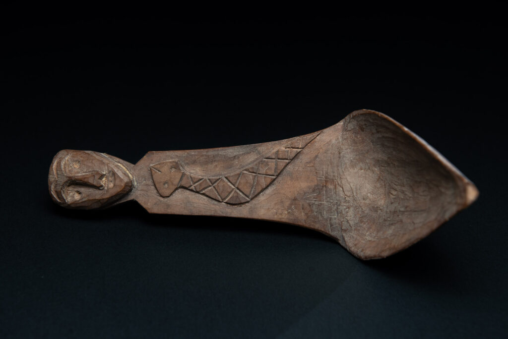 Old wooden spoon from the Paiwan tribe, carved with a one hundred pace snake at the back and one human head and sacred snake at the front.