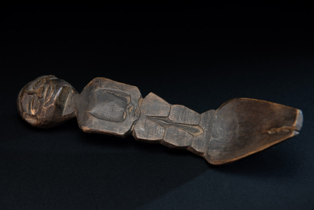 Old wooden spoon from the Paiwan tribe, carved with a standing figure .