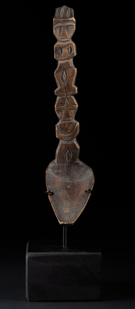 Old spoon from the Paiwan tribe, carved with two full-length standing figures, one above the other.