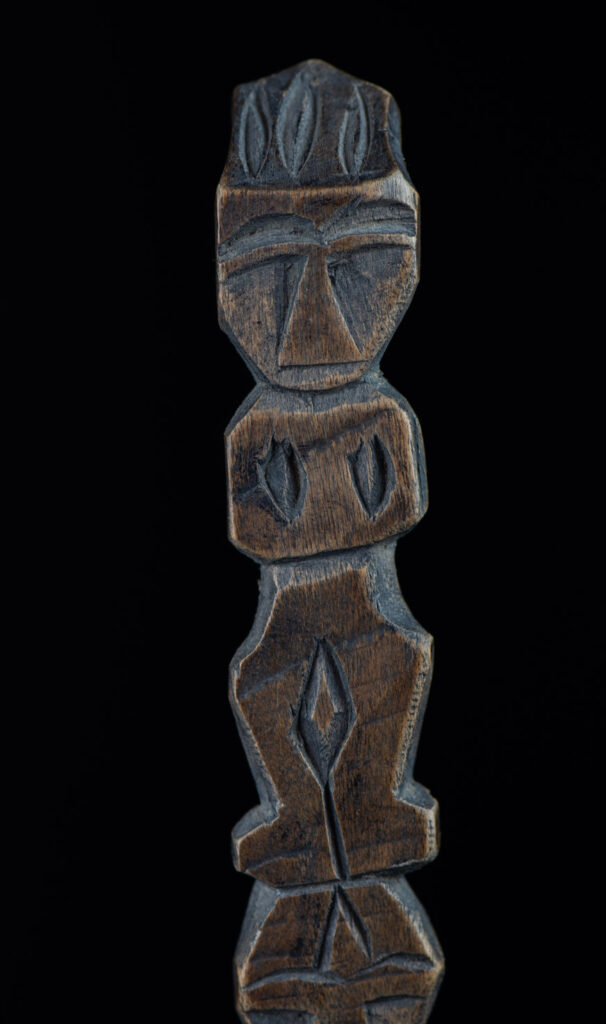 Old spoon from the Paiwan tribe, carved with two full-length standing figures, one above the other.